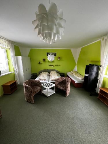 sypialnia z zielonymi ścianami, łóżkiem i żyrandolem w obiekcie Prenájom v súkromí Krompachy w mieście Krompachy