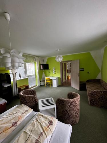 Prenájom v súkromí Krompachy في Krompachy: غرفة نوم بجدران خضراء وسرير وكراسي