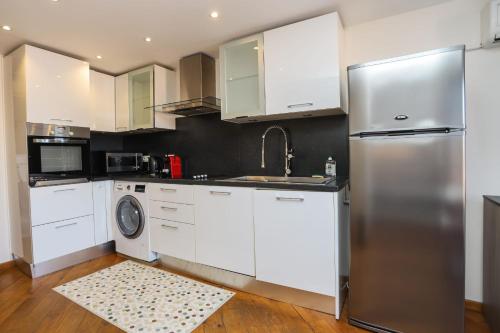 une cuisine avec des armoires blanches et un réfrigérateur en acier inoxydable dans l'établissement IMMOGROOM - Bright and Cosy - SUQUET - next to the beaches - AC, à Cannes