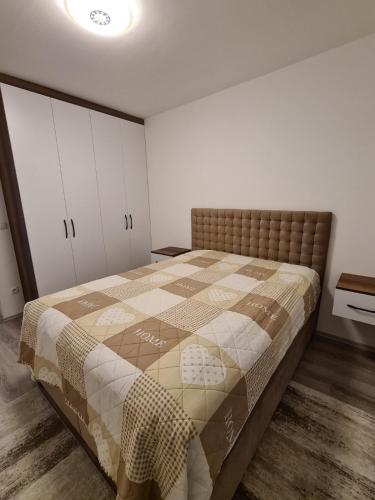 a bedroom with a bed with a quilt on it at Fush Kosov Apartment Center in Kosovo Polje