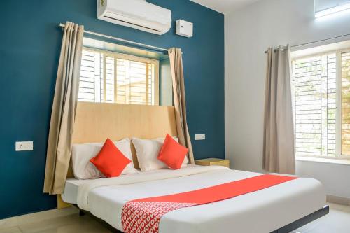 a bedroom with a large bed with red pillows at Welcome Inn Near DN Regalia in Khandagiri