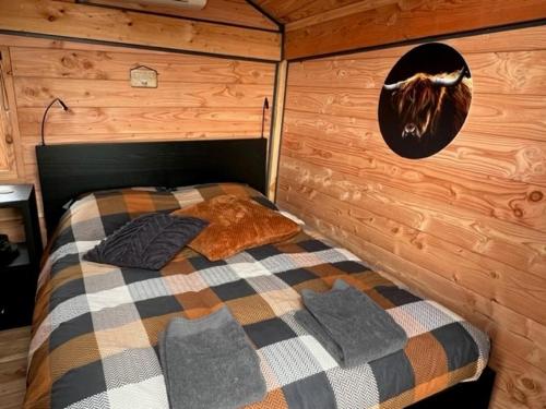a bedroom with a bed in a wooden cabin at Hoogte Huisje Schotland in Swalmen