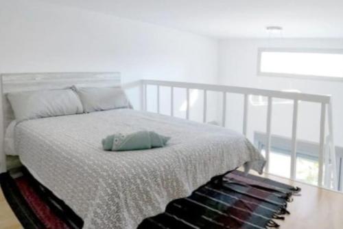 a bed with a white bedspread and a pile of books at Sun-Golf-Beach Villamartin in Alicante