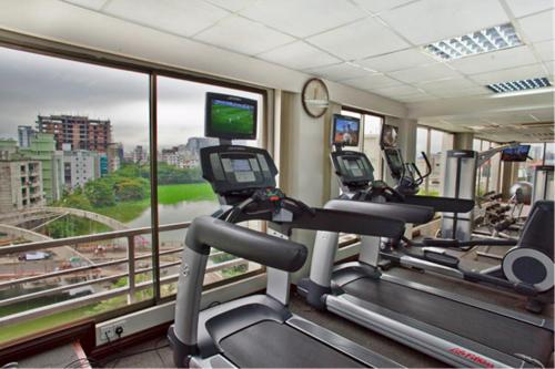 a gym with two tread machines and a window at Lakeshore Hotel & Apartments in Dhaka
