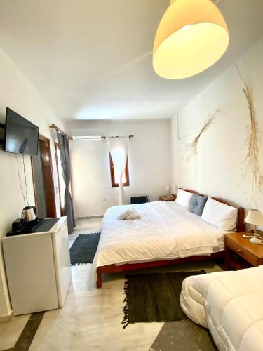 a bedroom with a large bed and a lamp at Costas Inn in Spílion