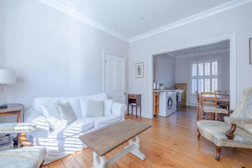 a living room with a white couch and a table at Charming 2 Bedroom Home in West London in London