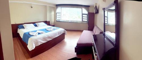 a hotel room with a bed and a mirror at Hotel Donde Marcelo in Baños