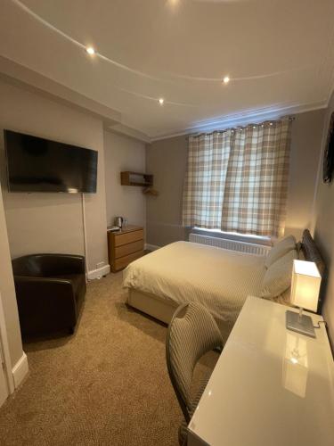 una camera d'albergo con letto, tavolo e sedia di Aabba Guest House a Whitley Bay