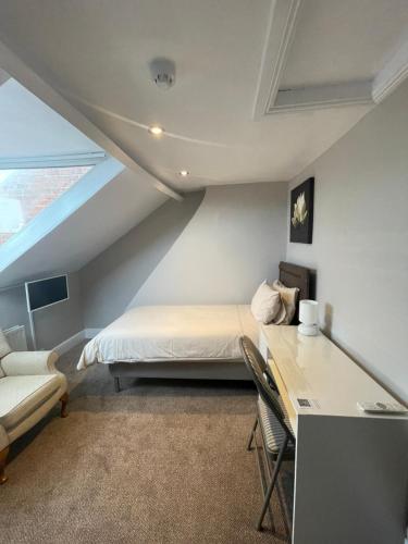 1 dormitorio con 1 cama y escritorio en una habitación en Aabba Guest House en Whitley Bay