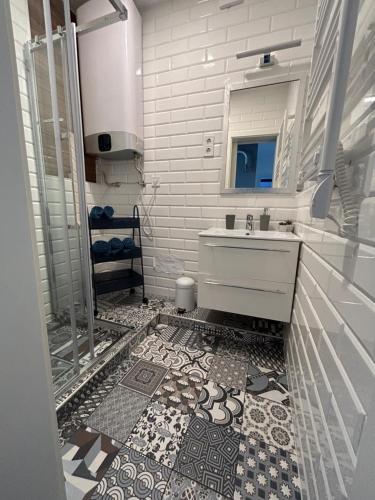 La salle de bains est pourvue d'un lavabo et d'un miroir. dans l'établissement GabEnd’i Apartman, à Eger