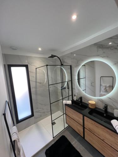 a bathroom with a large mirror and a sink at Villa bord de mer in Hyères