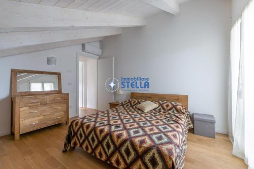 una camera con letto, cassettiera e specchio di Villa Stella a Lido di Jesolo
