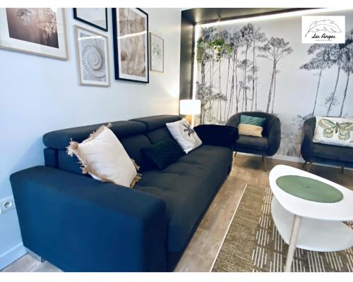 a living room with a black couch and a table at Le 9 de Cœur - 2 chambres - 6 couchages in Arras