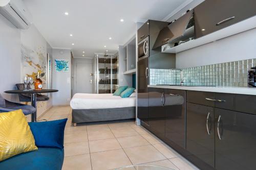 Cette chambre dispose d'une cuisine avec un lit en arrière-plan. dans l'établissement Easy love village naturiste, au Cap d'Agde