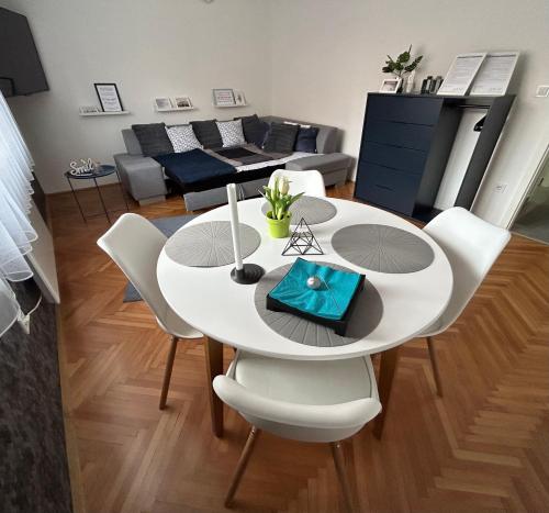 a white dining table and chairs in a living room at GabEnd’i Apartman in Eger