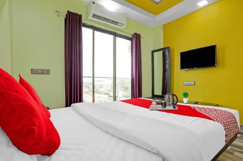 1 dormitorio con 1 cama grande con almohadas rojas y TV en Om Sai Ram Residency, en Bombay
