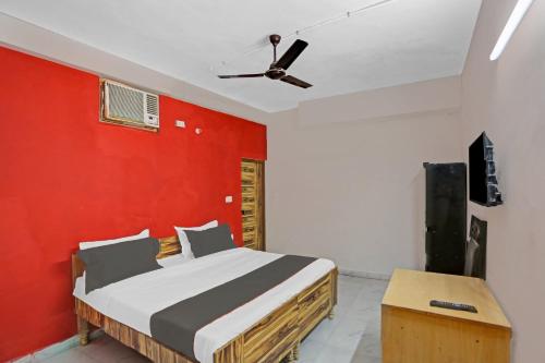 um quarto com uma cama e uma parede vermelha em Capital O Diamond 18 Near Worlds Of Wonder em Kālkāji Devi