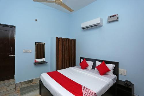 a bedroom with a bed with red pillows at OYO The Ambience in Bhubaneshwar