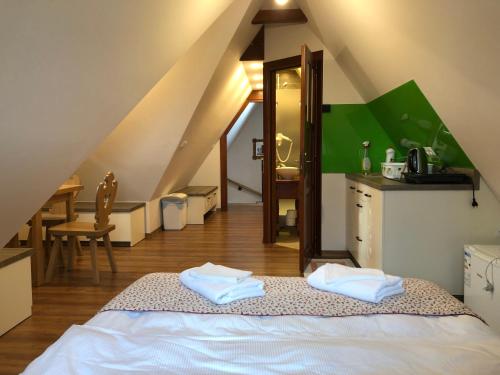 a attic room with a bed and a sink and a table at Apartamenty u Ani in Ząb