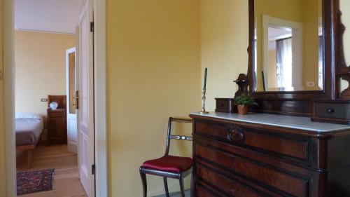 a room with a dresser with a mirror and a chair at B&B Casa Forster in Cannero Riviera