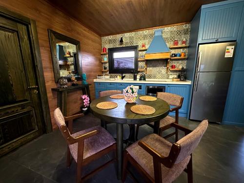 a kitchen with a table and chairs and a refrigerator at Runaway House - Qalacıq in Gabala