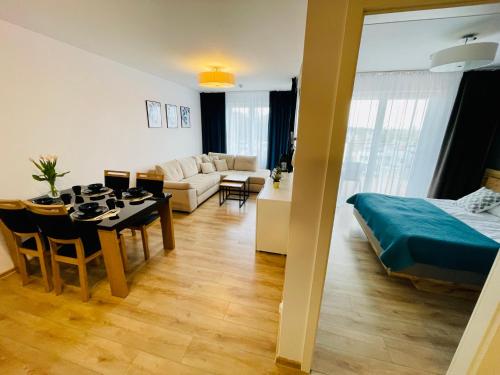 - un salon avec une table à manger et une chambre dans l'établissement Sun4You Polanki Park, à Kołobrzeg