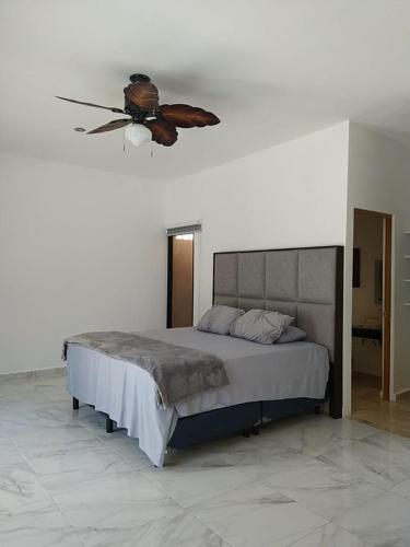 a bedroom with a bed with a ceiling fan at Casa Flamingo Telchac in Telchac Puerto