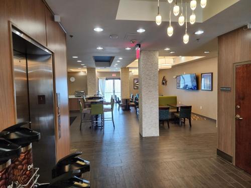 an empty lobby with tables and chairs in a building at Comfort Suites New Orleans East in New Orleans