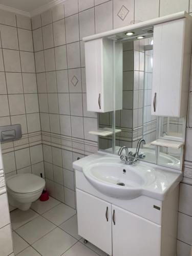 a white bathroom with a sink and a toilet at Belek Villa in Belek