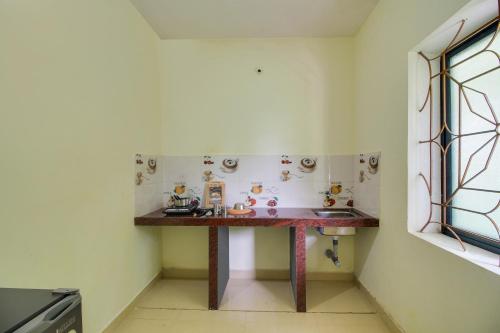 a small kitchen with a table and a sink at OYO 92630 Bharat Holiday Home in Saligao