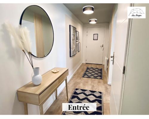 a hallway with a table and a mirror at Le 9 de Cœur - 2 chambres - 6 couchages in Arras