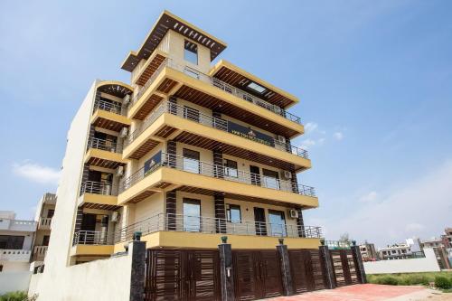 un edificio de apartamentos alto de color amarillo con una puerta en Super Capital O 62990 Harish Residency, en Gurgaon