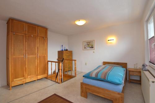 - une chambre avec un lit et une armoire en bois dans l'établissement Haus Gieselsberg, mit Aussicht auf Schmalkalden, à Schmalkalden