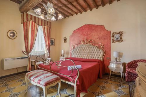 sypialnia z czerwonym łóżkiem i krzesłem w obiekcie Antica Residenza Santa Chiara -City Center w Lukce