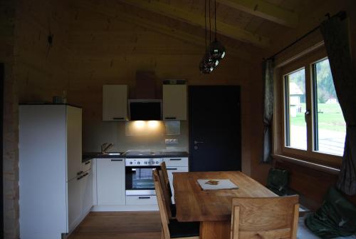 艾森奈茲的住宿－Ferienhaus-Eisenerz，一间带木桌的厨房和一间带炉灶的厨房
