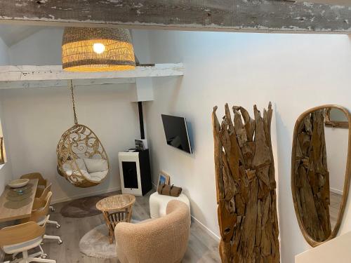 ein Wohnzimmer mit einem Tisch, Stühlen und einem Spiegel in der Unterkunft Au Petit Manoir in Socx