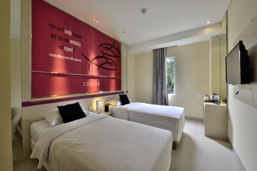 Postel nebo postele na pokoji v ubytování Zodiak Kebon Kawung by KAGUM Hotels