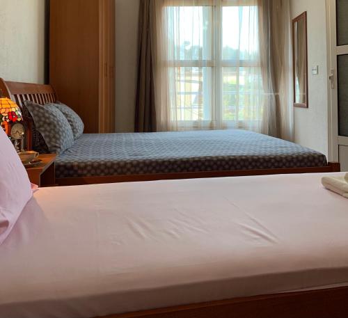 a bedroom with two beds and a window at Apartments Nuhi in Ulcinj