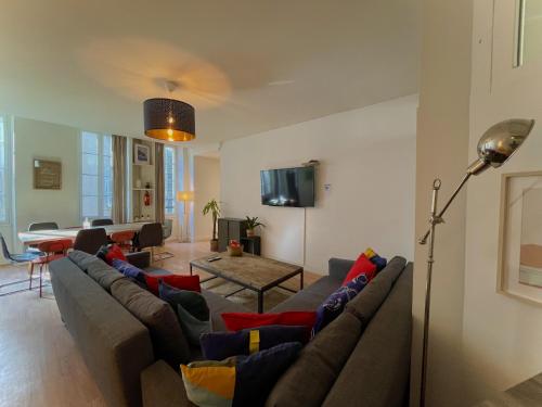 ein Wohnzimmer mit einem Sofa und einem Tisch in der Unterkunft Maï Homes - Le Cœur Canebière in Marseille