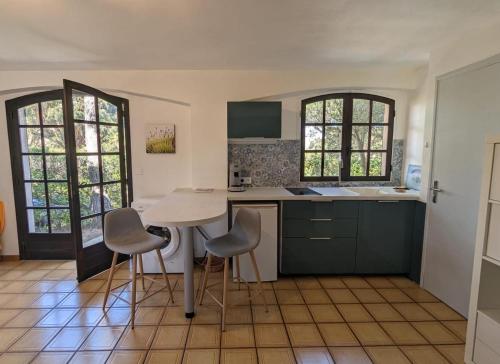 une cuisine avec une table et des chaises dans une pièce dans l'établissement Eucalyptus, calme entouré de verdure et près de la mer, à Saint-Aygulf