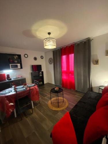 - un salon avec une table et une fenêtre rouge dans l'établissement Disneyland Paris - Calm & Cute STUDIO 6 Mins from RER A!, à Torcy