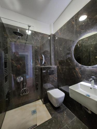 La salle de bains est pourvue d'un lavabo, de toilettes et d'une douche. dans l'établissement The Old School Boutique Hotel, à Syrrako
