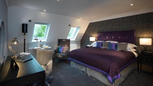 a bedroom with a large bed with a purple headboard at Northcote in Langho