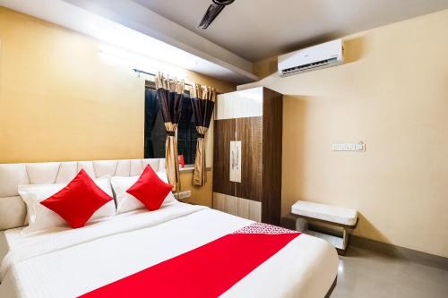 1 dormitorio con 1 cama grande con almohadas rojas en OYO Kuber Residency Near Birla Mandir, en Calcuta