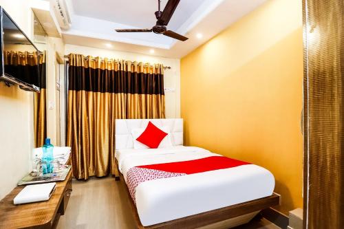 Habitación pequeña con cama, escritorio y cama sidx sidx en OYO Kuber Residency Near Birla Mandir, en Calcuta