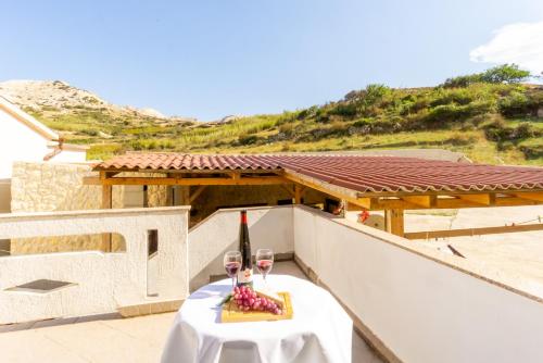 a table with two wine glasses on a balcony at Jasko i Jelica beautiful view in Metajna