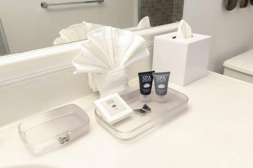 a bathroom counter with a tray with two glasses and a box at Stunning & Spacious Resort-Style Condo Across From Beach! in Miami Beach