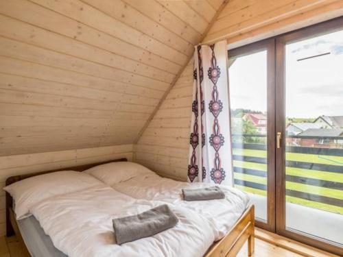 ein kleines Bett in einem Holzzimmer mit Fenster in der Unterkunft Domek Orawski in Zubrzyca Dolna