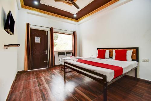 a bedroom with a large bed with red pillows at OYO Pine Tree in Mussoorie