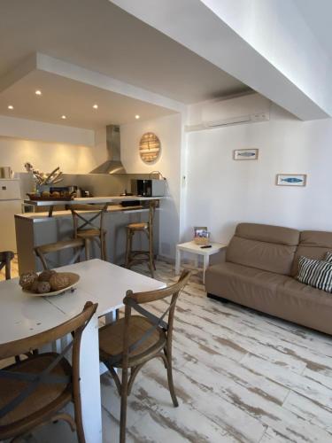 un salon avec un canapé et une table dans l'établissement Appartement Le Méditerranéen à 300m de la plage et au centre des Saintes Maries de la Mer LOCAMARGUE, à Saintes-Maries-de-la-Mer